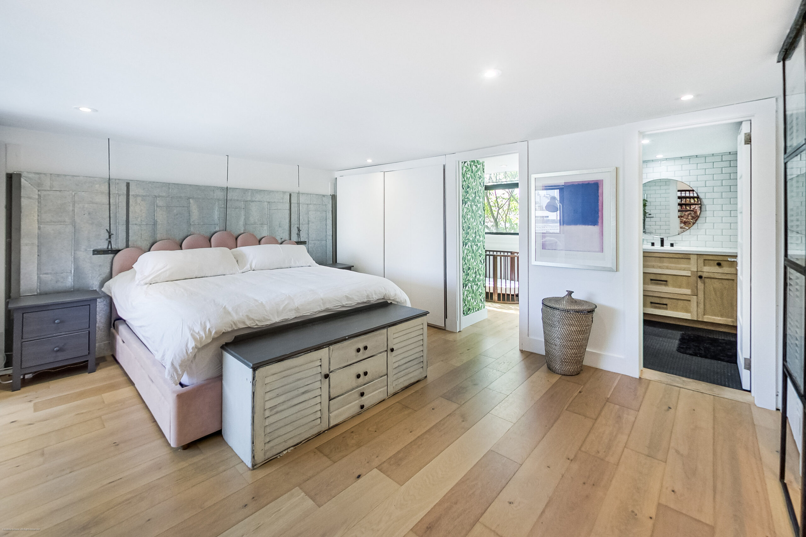 andreasimonecom | Liberty Village Toronto | Your Online Neighbourhood Guide Modern bedroom with a large bed, pink upholstered headboard, gray nightstands, and built-in white wardrobes; light hardwood floor.